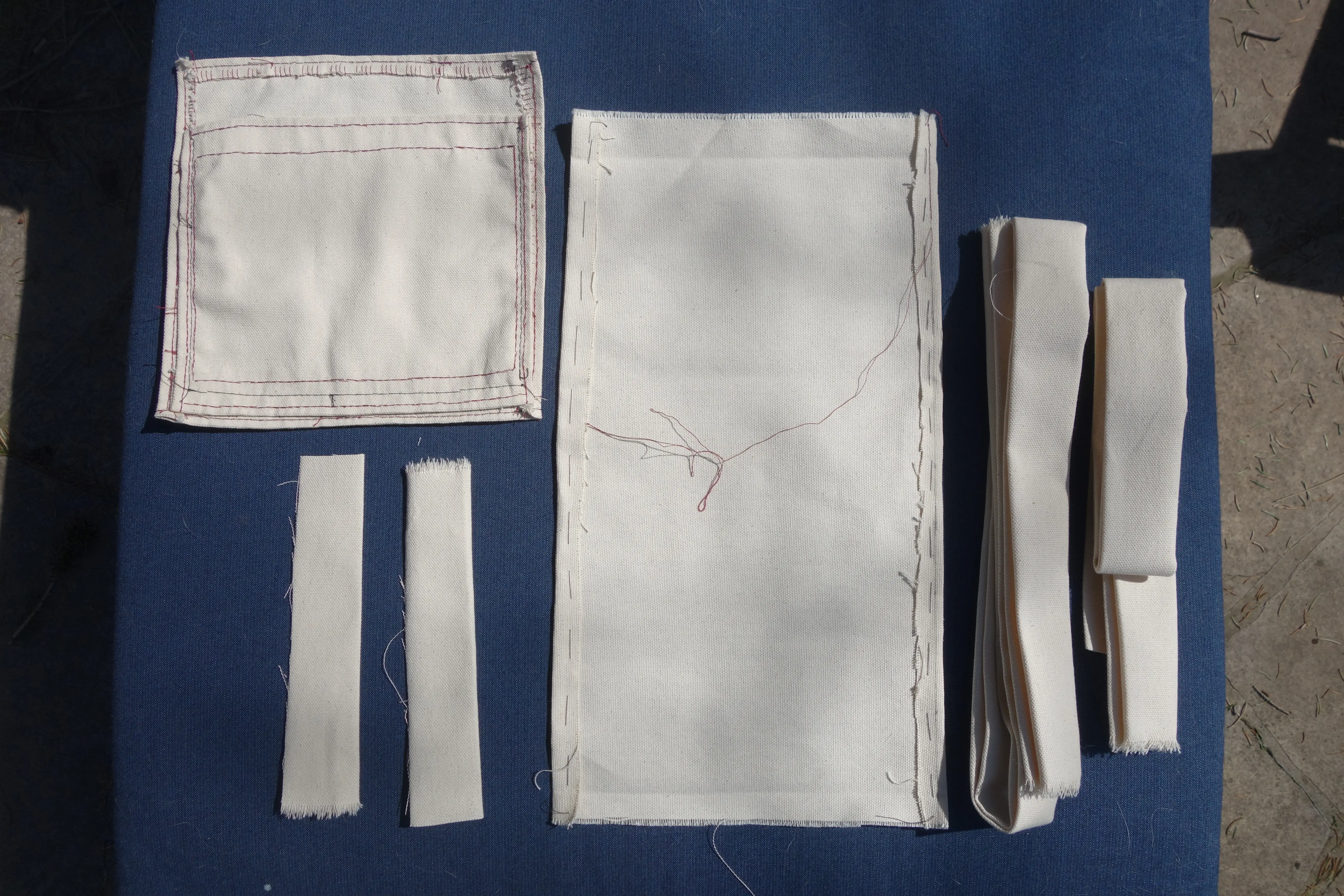 many pieces of canvas of different sizes, some with stitching