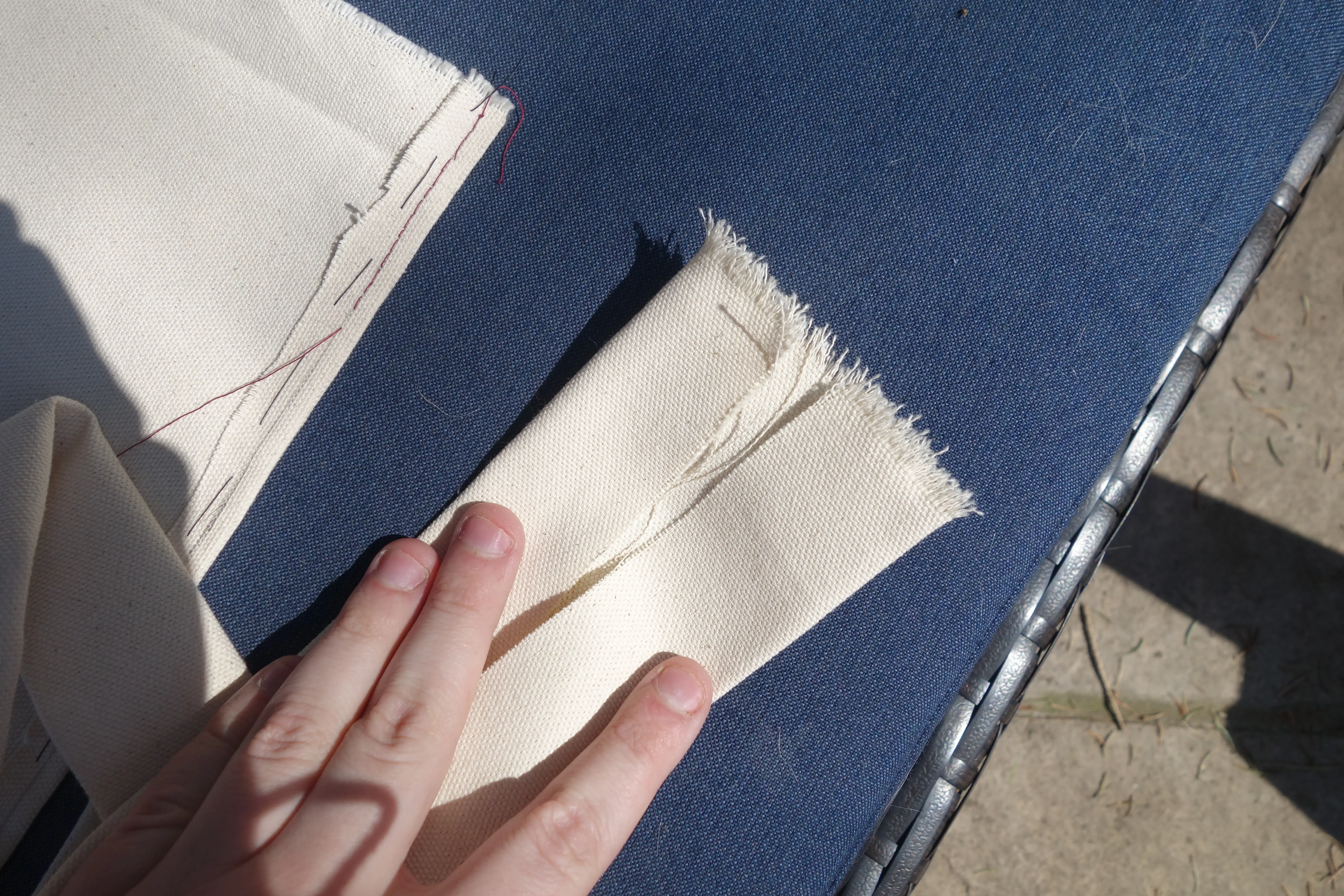 a large strip of fabric that has been folded is held open by two fingers