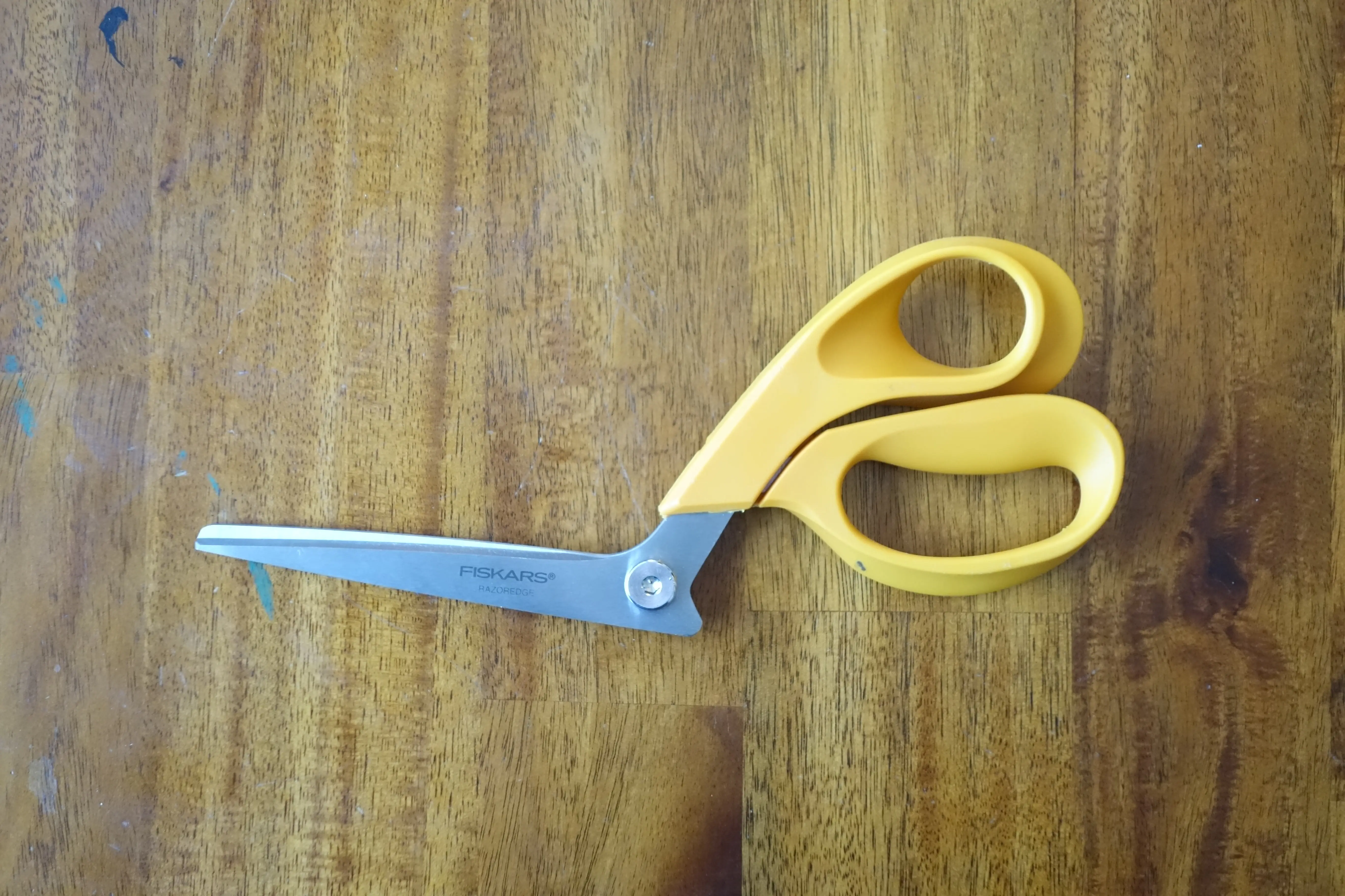a pair of fabric shears with a yellow plastic handle