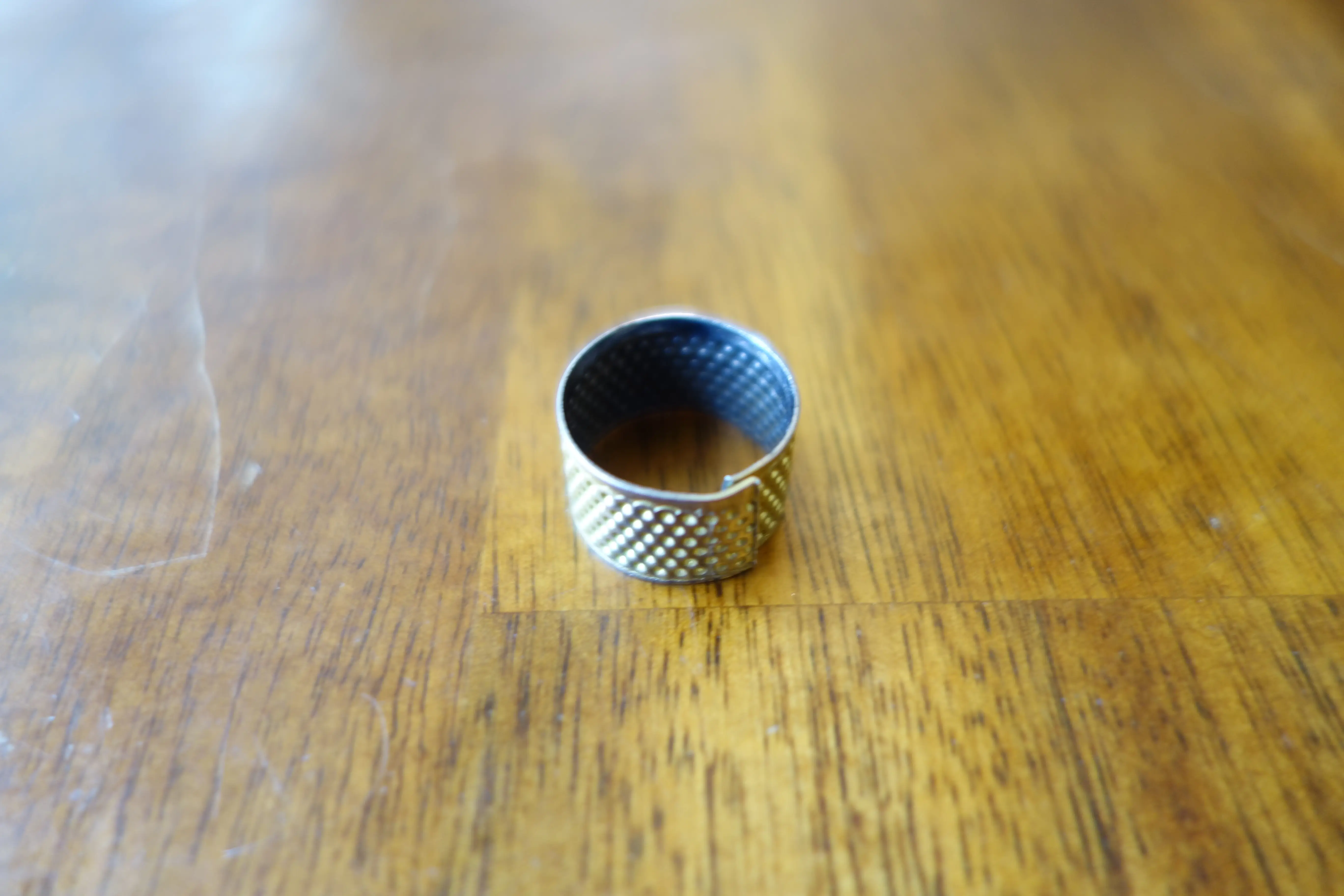 an adjustable metal thimble band ring with a worn gold finish